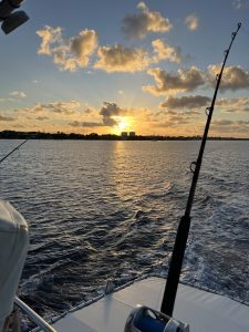 Golden sunrise over Bonaire seen past a trolling rod and reel on the deck of the Fishtales big game fishing boat.